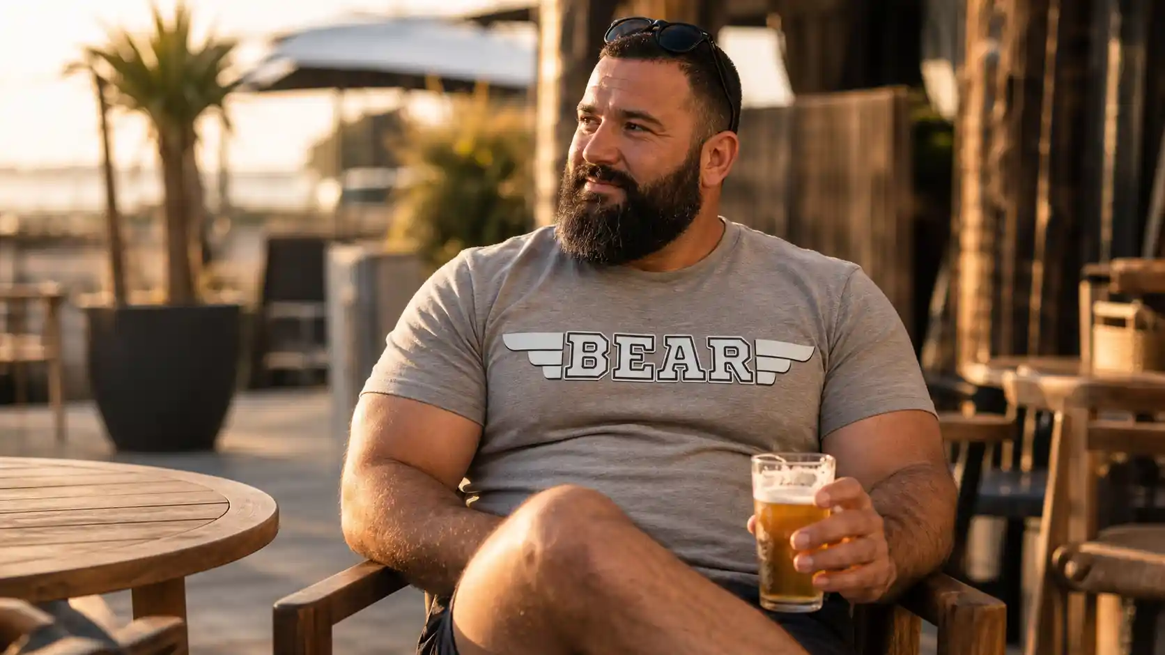 Bear corpulento sentado en una terraza con camiseta gris estampada,